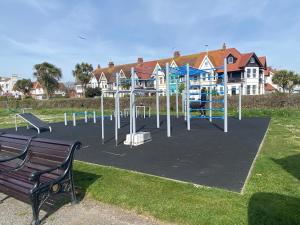 a playground in a park with a bench at WORTHING BEACH 180 - 2 bed seafront apartment with private parking in Worthing