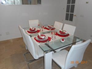 mesa de comedor con sillas blancas y mesa de cristal en 2105-Apt 2 bedrooms, on the beach, port view, pool, en Manilva