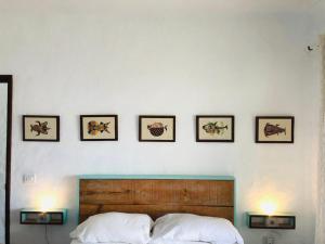 a bedroom with a bed with four pictures on the wall at Ocean’s Eleven Punta Mujeres in Punta de Mujeres