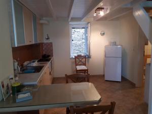 eine Küche mit einem weißen Kühlschrank und einem Tisch in der Unterkunft Roula's Suites in Ándros