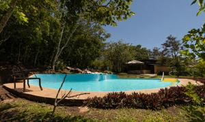 a large blue swimming pool in a yard at Colinas del Miravalles Hotel & Hot Springs in Hacienda Guayabo