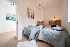 2 łóżka w sypialni z białymi ścianami i drewnianą podłogą w obiekcie Casa Giulia with heated pool w mieście Privlaka +37 zdjęć