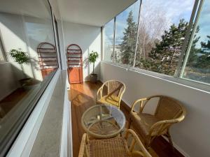 Zimmer mit 2 Stühlen und einem Tisch und einigen Fenstern in der Unterkunft Spacious 3bd top floor flat close to lake (103m²) in Klagenfurt am Wörthersee