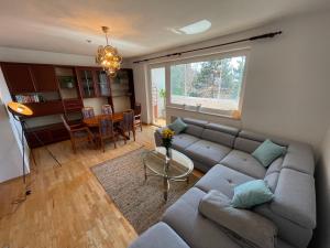 ein Wohnzimmer mit einer Couch und einem Tisch in der Unterkunft Spacious 3bd top floor flat close to lake (103m²) in Klagenfurt am Wörthersee