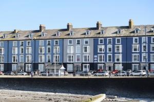 a large blue building with cars parked in front of it at Seaside Apartment in Aberystwyth