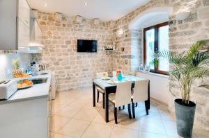 een keuken en eetkamer met een tafel en stoelen bij La Dolce Vita Apartments in Kotor