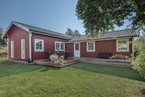 una casa roja con terraza y patio en Fjällbacka Villa en Fjällbacka