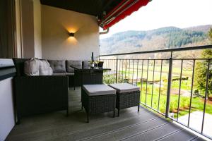 Balcón con sofá, mesa y vistas en Rieslingresidenz, en Traben-Trarbach