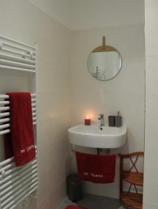 La salle de bains est pourvue d'un lavabo, d'un miroir et de serviettes rouges. dans l'établissement Le Case di Sonia TRE GEMME RUBINO Fucecchio, à Fucecchio