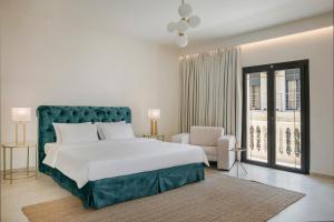 een slaapkamer met een groot bed en een stoel bij Alley Boutique Hotel and Spa in Argostoli