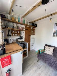 a kitchen with a couch in a small room at Mr Hares shepherd hut in Mellis