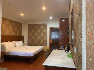 um quarto de hotel com duas camas e uma secretária em LUXOR EMPIRE em Pantai Cenang