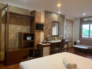 um quarto de hotel com uma cama, uma secretária e uma mesa em LUXOR EMPIRE em Pantai Cenang