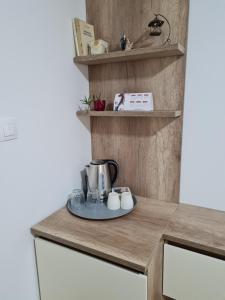 a kitchen counter with a coffee maker on a plate at Bojana Apartment Penthouse in Negotino