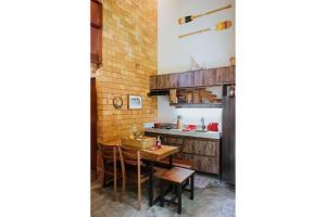 a kitchen with a wooden table and a counter at Vila do Porto, Praia do Patacho - Bangalô Toque in Pôrto de Pedras