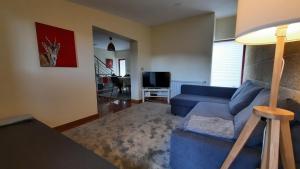 a living room with a blue couch and a table at Villas do Laboreiro - Casa 8 in Castro Laboreiro