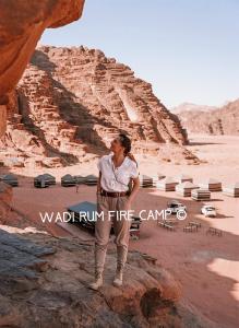 a woman standing on a rock in the desert at Wadi Rum Fire Camp in Wadi Rum