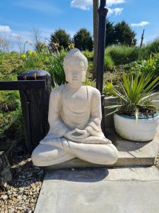 a statue of aitating woman sitting on the ground at Green Haven in Friskney