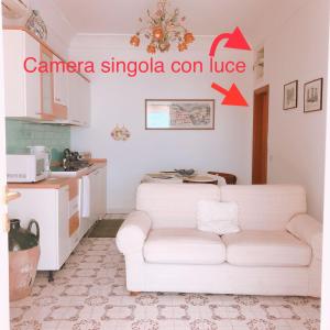 a living room with a white couch and a kitchen at Casa Marta vacation home in Positano in Positano