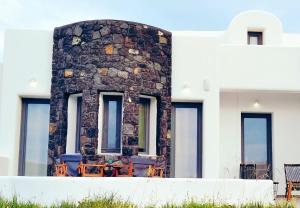 a building with a stone wall and windows at Four Levels Villa in Imerovigli