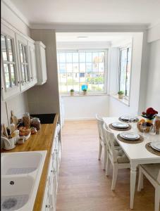 a kitchen with a white table and chairs in a room at Villa Rafa in Costa Nova