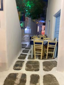 un restaurante con mesas y sillas en un suelo de piedra en BUDGET DOWNTOWN APARTMENT- Harma I, en Mykonos ciudad