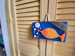 Casa Flavin Favignana في فافينانا: باب زينة لسمكة معلقة على باب