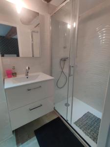 bagno bianco con doccia e lavandino di Logement neuf centre du village aux pieds du château a Grimaud