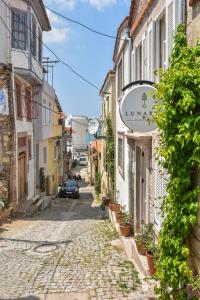 un vicolo in un centro storico con un cartello su un edificio di Lunaria Guest House a Ayvalık