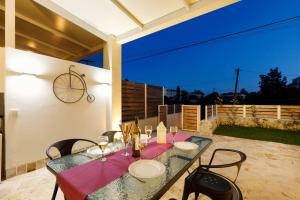 a table with chairs and wine bottles on a patio at Senses Suites in Dassia