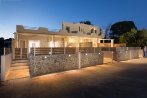 uma casa com uma parede de pedra em frente em Senses Suites em Dassia