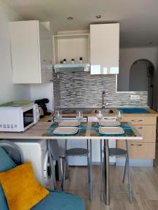 a kitchen with a table with chairs and a microwave at Blue Butterflies Studio in Empuriabrava