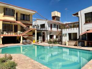 a swimming pool in front of a building at Hotel Mitru in Tupiza