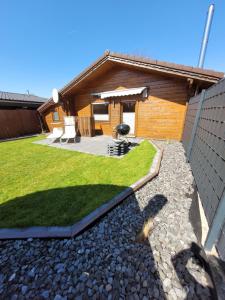 a backyard with a house with a patio and grass at Ferienbutze in Molbergen