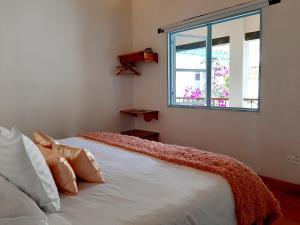 a bedroom with a white bed with a window at Hotel Casa Boutique Villa de Leyva in Villa de Leyva