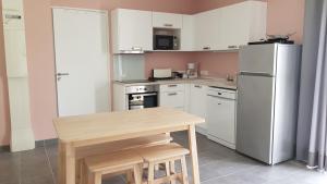 a kitchen with a wooden table and a refrigerator at La Chouette d'Amboise in Amboise