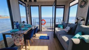 a living room with a couch and a table at Domki na wodzie Jastarnia - Houseboat in Jastarnia