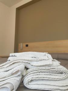 una pila de toallas blancas sentadas encima de una cama en Bed & Breakfast Memory, en Canzano