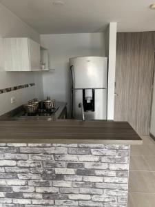 a kitchen with a brick counter top and a refrigerator at Apartasuite 01 in Pereira