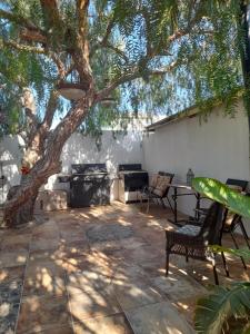a patio with a tree and a table and chairs at BAJA SUITES UPSTAIRS in Punta Abreojos