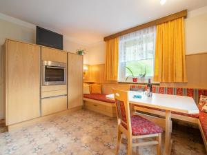 a small room with a desk and a kitchen with two beds at Ferienhaus Nössig in Auffach