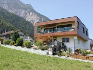 uma casa numa colina com montanhas ao fundo em Bitschnau em Vandans