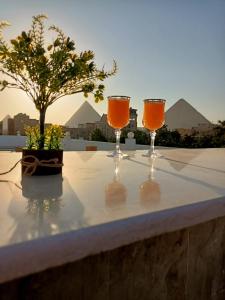 drie wijnglazen zittend op een tafel met een boom bij Nefertiti pyramids view in Caïro