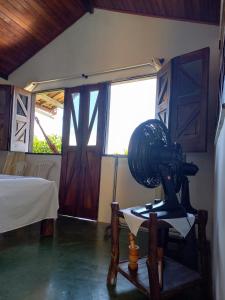 Habitación con ventilador en la mesa y cama en Chalé na Praia da Tiririca en Itacaré