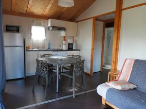 eine Küche mit einem Tisch und Stühlen im Zimmer in der Unterkunft Chalet 1 au coeur des volcans in Bromont-Lamothe