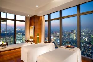 a hotel room with two large windows overlooking the ocean at Mandarin Oriental Tokyo in Tokyo