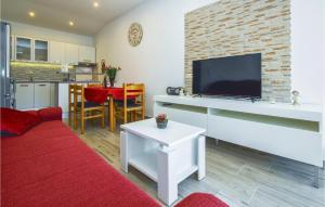 sala de estar con sofá rojo y TV de pantalla plana en Amazing Apartment In Ostrvica With Jacuzzi, en Ostrvica