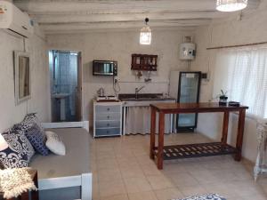 a kitchen with a couch and a table in a room at Rincon La Magda in Ciudad Lujan de Cuyo