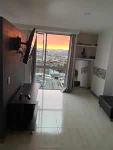 una sala de estar con una gran puerta de cristal con vistas en Apartasuite 01 en Pereira