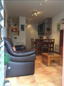 a living room with a leather couch and a table at ELUR ETXEA in Isaba